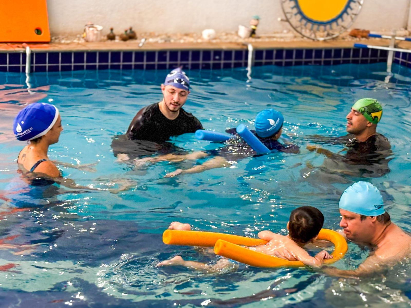 Sessão de fisioterapia aquática em pequeno grupo, com flutuadores